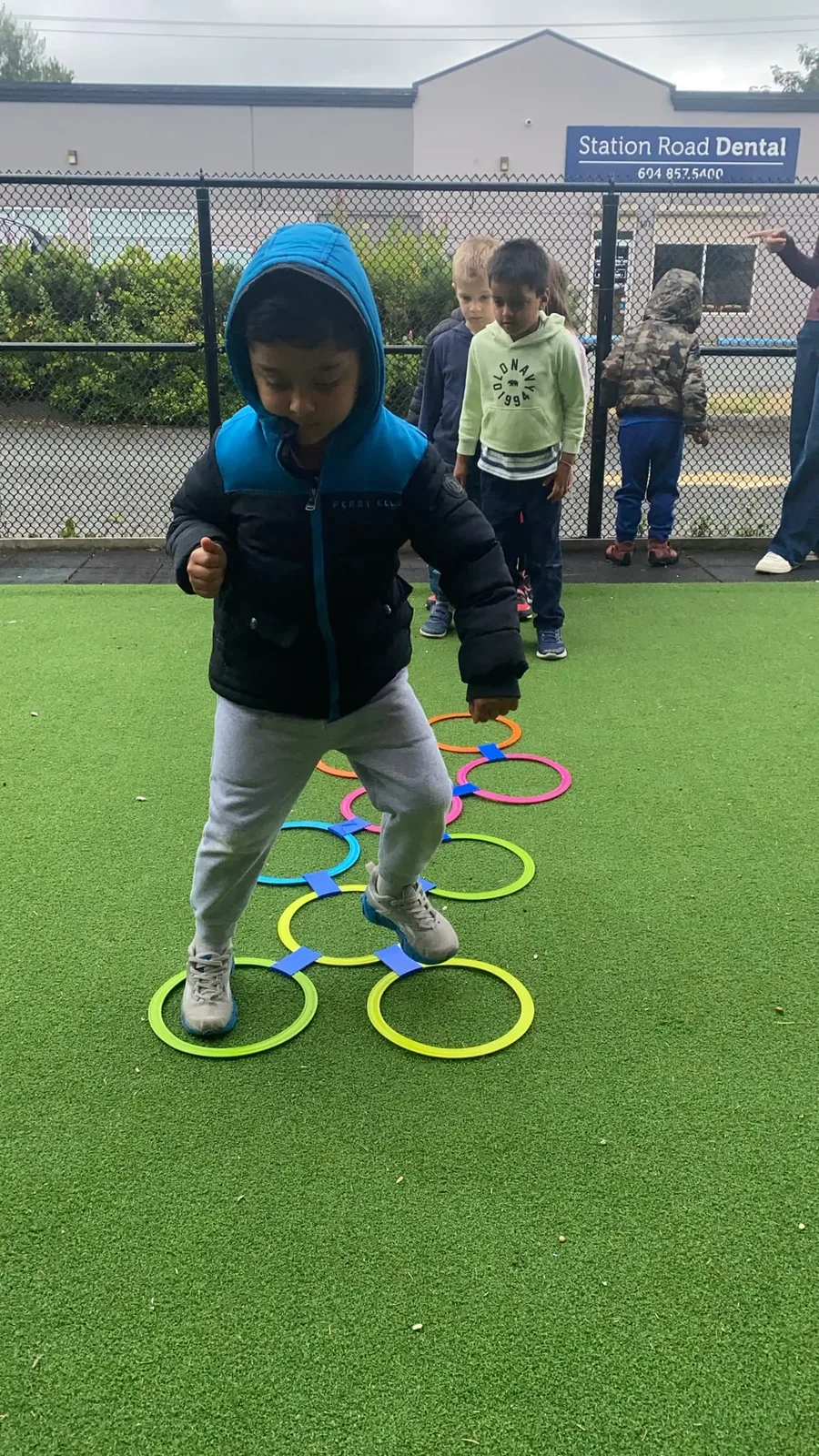 A child hopping through a colourful ring agility course outdoors